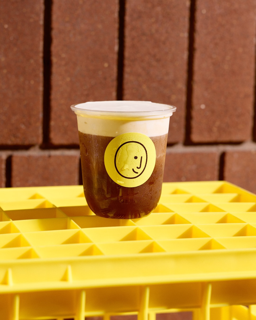 Goodside iced coffee with cold foam and the yellow smiley sticker